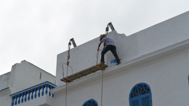 壁の塗装屋さん。見るからに不安定だ・・・命がけの仕事ですね